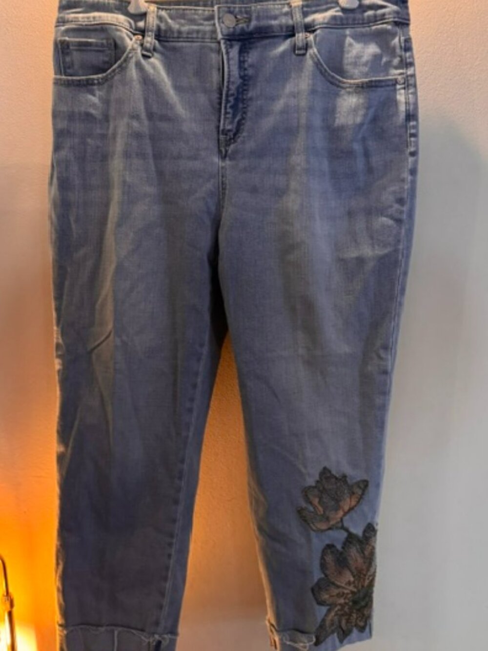 Nine West Capri jeans feature a faded blue wash and floral embroidery hem